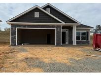 New construction home featuring a stone facade, attached garage, and contemporary design at 121 Northwood Dr, Fuquay Varina, NC 27526