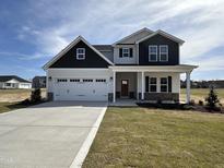 Charming two-story home features a two-car garage, inviting front porch, and a well-manicured lawn at 141 Trescott St, Smithfield, NC 27577