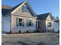 Two-story home with gray siding, attached garage, and landscaped yard at 15 Long Needle Ct # 38, Youngsville, NC 27596