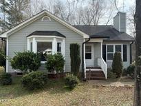 Charming single-story home with a gray exterior, chimney, and manicured front yard at 2213 Stephanie Ln, Clayton, NC 27520