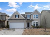 Two-story house with beige siding, a white garage door, and a neatly landscaped lawn at 43 Dando St, Garner, NC 27529