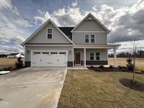 Charming two-story home with a two-car garage, and a well-manicured lawn in a desirable neighborhood at 65 Barony Ln, Smithfield, NC 27577