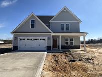 Two-story home boasts a covered porch and an attached two-car garage at 65 Barony Ln, Smithfield, NC 27577