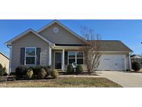 Tan house with a white garage door and landscaping at 670 Meadowtop Cir, Burlington, NC 27217