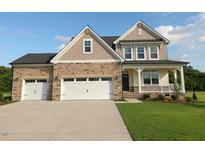 Charming two-story home featuring a stone facade, inviting front porch, and a spacious three-car garage at 71 Priming Way, Angier, NC 27501