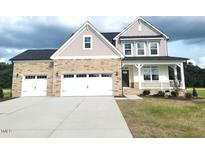 Charming two-story home featuring a three-car garage and a welcoming front porch, creating instant curb appeal at 71 Priming Way, Angier, NC 27501