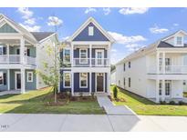 Charming blue two-story home with a front porch and manicured lawn under a clear sky at 720 Georgias Landing Pkwy # 11, Raleigh, NC 27603