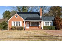 Brick ranch house with solar panels, landscaped yard, and paved driveway at 801 Williamsboro St, Oxford, NC 27565