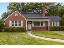 Charming brick home featuring white-framed windows, brick chimney, and well-maintained landscaping at 801 Williamsboro St, Oxford, NC 27565