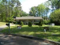 Charming single-story home with a well-manicured lawn and mature trees at 108 Cheney Ct, Garner, NC 27529