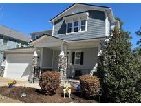 Charming two-story home with gray siding, stone accents, a covered porch, and well-manicured landscaping at 1617 Old Bramble Ln, Fuquay Varina, NC 27526