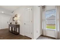 Bright entryway with hardwood floors, coat closet, and natural light at 2180 Monk Dr, Haw River, NC 27258
