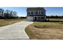 Two-story house with gray siding, a white door, and a curved driveway at 25 Harvest Hills Ln, Dunn, NC 28334