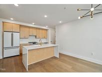 Bright kitchen features stainless steel appliances, light wood cabinets, white countertops, and a kitchen island at 29 Enterprise St # 309, Raleigh, NC 27607