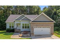 Charming single Gathering home featuring a brick and vinyl exterior, attached two car garage, and well maintained lawn at 46 Trusting Ln, Middlesex, NC 27557