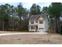 Two-story house with beige siding, red roof accents, and a two-car garage at 496 Omaha Dr, Broadway, NC 27505