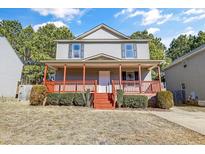 Two-story house with gray siding, red porch, and well-maintained landscaping at 502 Randolph Dr, Clayton, NC 27520