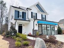 Two-story home with white siding, blue accents, and landscaping at 5112 N River Sand Trl, Raleigh, NC 27604