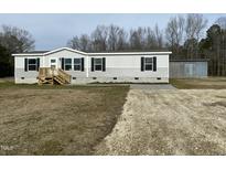 Single-wide manufactured home with detached shed and gravel driveway at 1039 Branch Chapel Church Rd, Selma, NC 27576