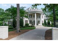 Stately white home with grand columns, elegant landscaping, and a circular driveway at 11201 Jonas Ridge Ln, Raleigh, NC 27613