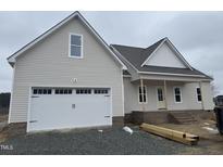 Two-story house with a large white garage door and covered front porch at 1178 Sheriff Johnson Rd, Lillington, NC 27546