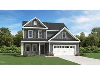 Two-story house with gray siding, white garage door, and stone accents at 1310 Hazelnut Ridge Ln, Knightdale, NC 27545