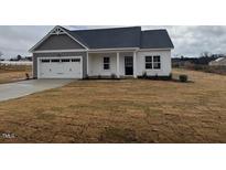 Charming single-Gathering home features a two-car garage, gray accents, and a well-manicured lawn at 135 Jones Creek Ln Ln, Lillington, NC 27546