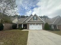 Brick ranch home with a white door and two-car garage at 166 Easy Wind Ln, Garner, NC 27529