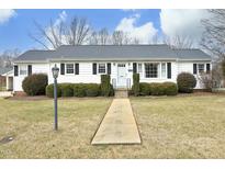 White Ranch home with gray roof, landscaping, and walkway at 1805 Brown Ave, Burlington, NC 27215