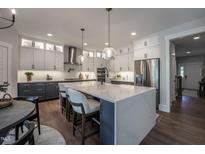 Modern kitchen with two-toned cabinetry, large island, and stainless steel appliances at 306 White Magnolia Ln, Fuquay Varina, NC 27526