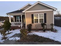 Tan house with a white porch and black shutters, snow on the ground at 5430 Neuse Ridge Rd, Raleigh, NC 27610