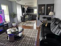 Open-concept living room featuring modern furnishings and decor, connected to the kitchen and dining area at 5430 Neuse Ridge Rd, Raleigh, NC 27610