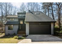 Modern two-story house with gray siding, black garage door, and landscaped lawn at 8309 Stryker Ct, Raleigh, NC 27615