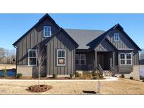 Craftsman style home with dark gray siding, brick accents, and a welcoming front porch at 1 Kelsey Ct, Hillsborough, NC 27278