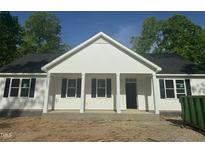 Inviting home featuring a classic white exterior, black shutters, and covered front porch at 132 Black Cloud Dr, Louisburg, NC 27549