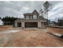Two-story home with attached three-car garage under construction on a cloudy day at 18 Bonnybrook Ct, Selma, NC 27576