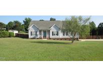 Charming one-story home with a well-manicured lawn, dark shutters, and inviting front porch at 35 Meadow Ln, Franklinton, NC 27525