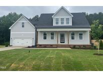 Charming new construction home featuring a welcoming front porch and attached two-car garage at 404 Brodie Rose Landing Way, Smithfield, NC 27577