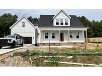 Charming two-story home with gray siding, black roof and welcoming front porch, perfect for relaxing at 404 Brodie Rose Landing Way, Smithfield, NC 27577