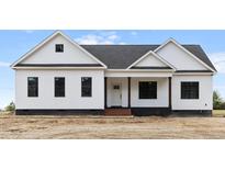 Newly constructed home featuring a modern farmhouse design, showcasing its symmetrical facade and covered front porch at 541 Delma Grimes Rd, Coats, NC 27521