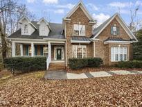 Brick house with a two-car driveway and landscaping at 5621 Voorhees Ln, Holly Springs, NC 27540