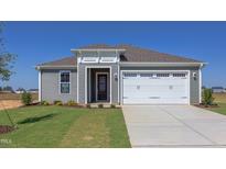 Gray house with white garage doors and landscaping at 104 Barn Door Dr, Lillington, NC 27546