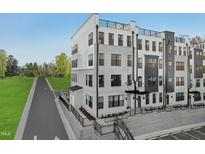 Modern townhome featuring a stylish gray and white exterior with multiple windows and rooftop access, perfect for city living at 109 Ailey Brook Way # 200, Wake Forest, NC 27587