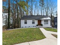 Charming white brick ranch home with a manicured lawn and walkway at 1128 E Geer St, Durham, NC 27704