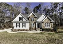 Charming two-story home with stone and siding, surrounded by mature trees and a well-manicured lawn at 1201 Rivermead Ln, Wake Forest, NC 27587