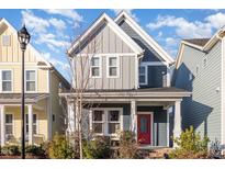 Two-story home with gray siding, red door, and front porch at 1413 Big Falls Dr, Wendell, NC 27591