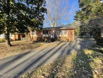 Brick ranch home with a long driveway and mature trees at 2801 O'Shanter Pl, Raleigh, NC 27604