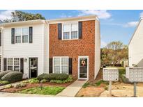 Charming townhome showcasing a well-maintained brick facade and lovely landscaped front yard at 30 Cheltenham Dr, Clayton, NC 27520