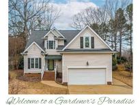 Two-story house with beige siding, gray roof, and attached garage at 6328 Nowell Pointe Dr, Raleigh, NC 27607