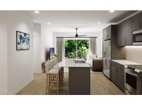 Modern kitchen with island, stainless steel appliances, and gray cabinetry at 711 E Lenoir St # 207, Raleigh, NC 27601